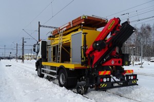 Při jízdě po koleji je přenos výkonu zajištěn hydrostaticky pomocí čerpadla a hydromotorů. Vozidlo je dále vybaveno kamerovým systémem CCTV pro jízdu vzad se zobrazením v kabině na LCD displeji, drážním osvětlením a systémem osvětlení pro práci v noci.