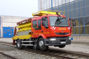 Bei Schienenfahrt erfolgt die Leistungsübertragung mittels Fahrzeugreifen. Das Fahrzeug ist mit CCTV Kamerasystem für Rückwärtsfahrt, dargestellt auf LCD-Display im Fahrerhaus, Eisenbahn-Scheinwerfer und Beleuchtung für Nachtarbeit ausgerüstet. Die Betätigung aller Betriebstätigkeite bei Schienenfahrt wird elektrisch aus der Fahrerkabine gesteuert, Schienenfahrgestelle werden automatisch betätigt, am Bordcomputer überwacht.