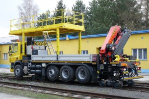 Oba železniční podvozky jsou čtyřkolové a jsou umístěny za silničními nápravami. Vozidlo je vybaveno hydrostatickým pohonem a lze využít i mikropohon. Zadní otočný železniční podvozek umožňuje snadnější nakolejení.